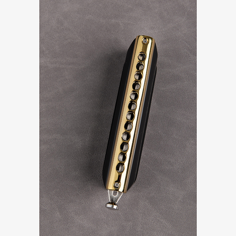 Details of a 12-hole chromatic harmonica in two colors - black color