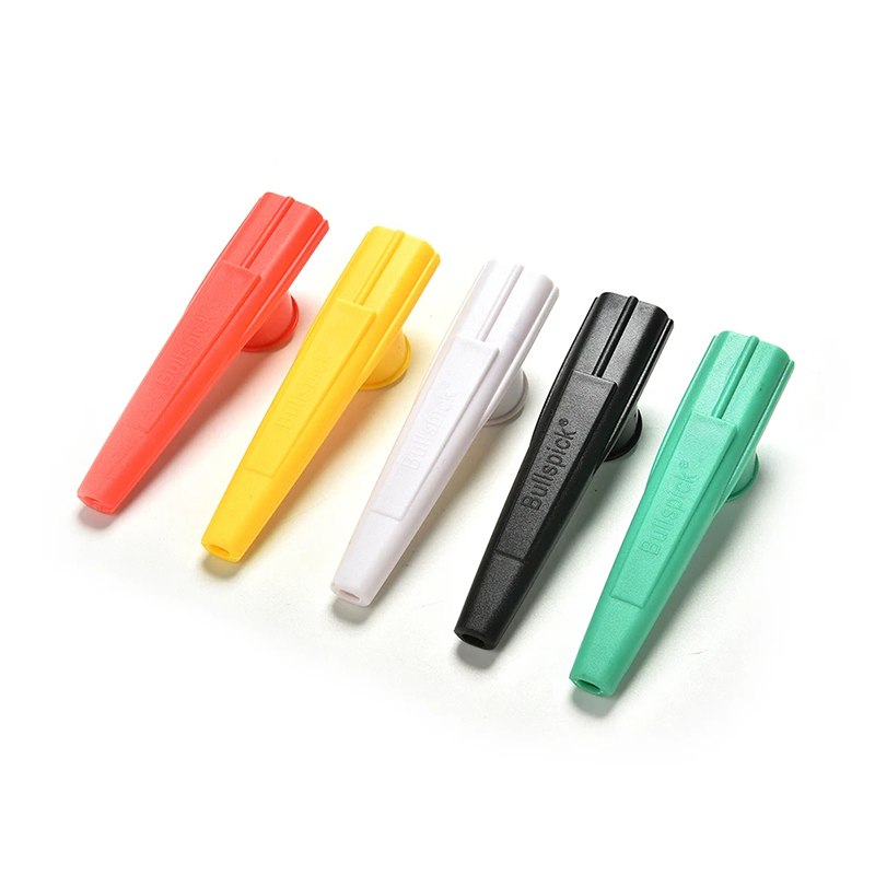 Rear view of a small, randomly colored plastic kazoo.