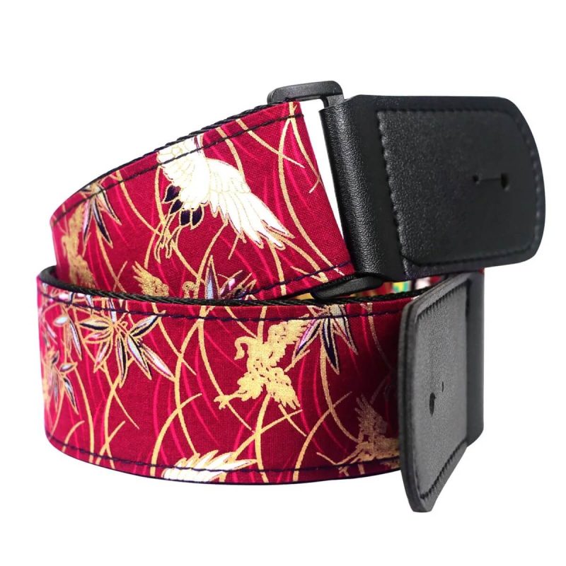 Details of a Japanese-inspired guitar strap featuring a flying crane design in red color.