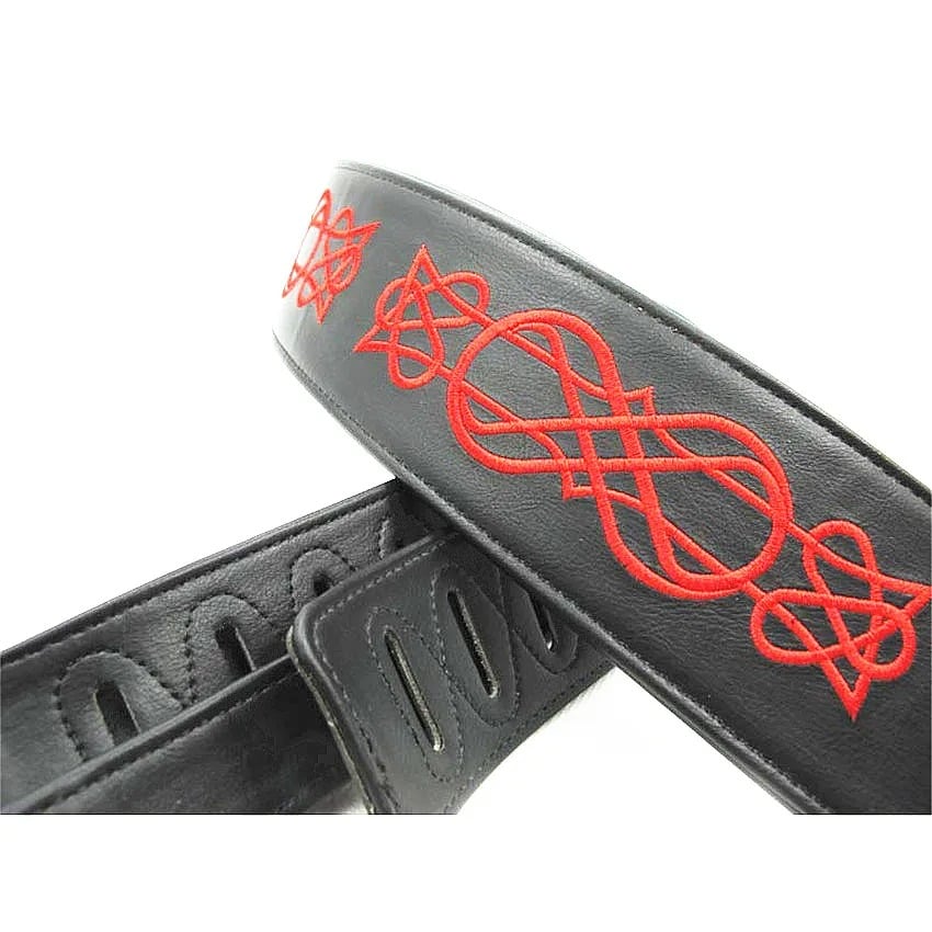 Details of embroidery on a leather bass guitar strap with an iron cross pattern