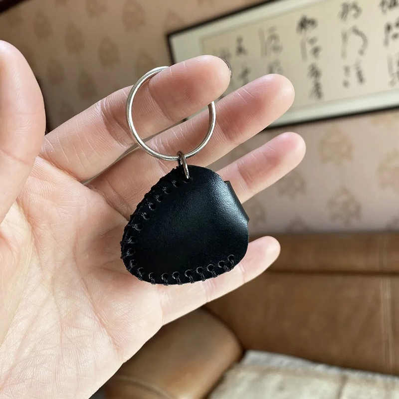 Back view of a guitar keychain made of genuine leather with a pick case
