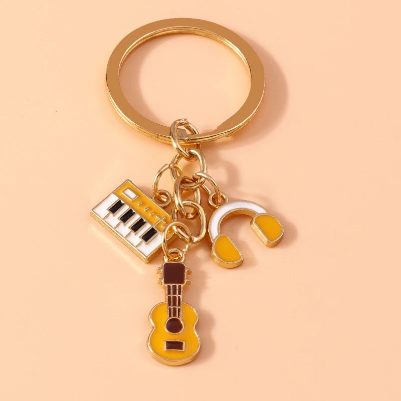 Metal keychain of a guitar and musical instruments in yellow color