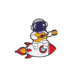 Enamel pins of a Cosmonaut playing the guitar on a rocket