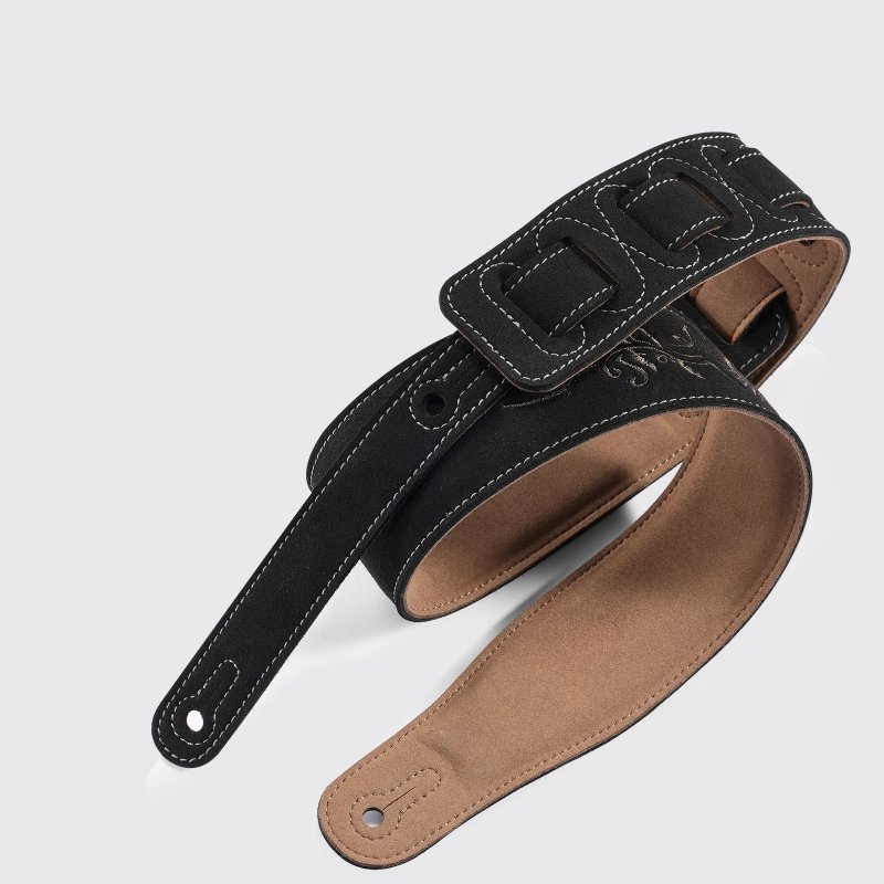 Detail of a suede leather guitar strap with sun embroidery