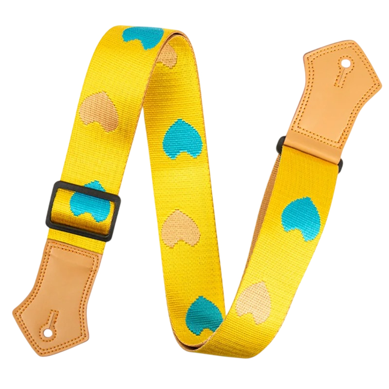 Vintage guitar strap with blue hearts and sand on a yellow background