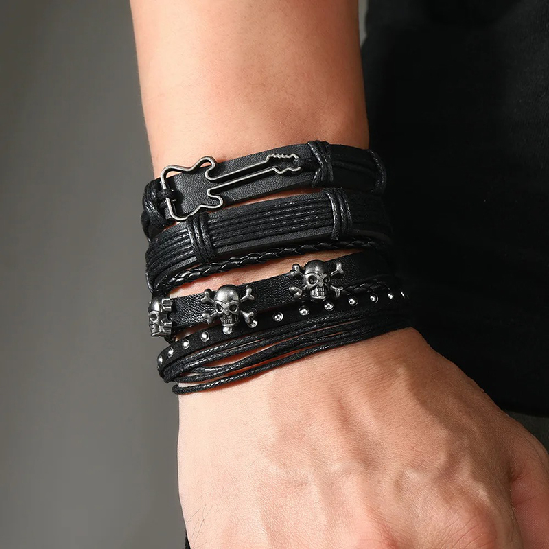 View of a rock bracelet with a guitar and metallic skull design.