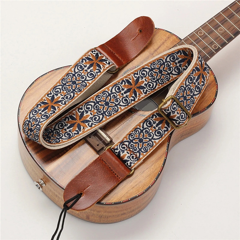Overall view of the vintage-style ukulele strap with bohemian flowers in blue and ochre.