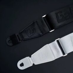 Sangles de guitare Power Grip noire et blanche sur fond noir, attaches auto-lock et boucles de réglage métalliques